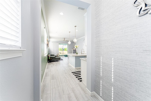 hall featuring ornamental molding and sink