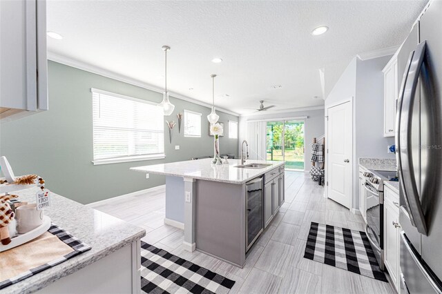 kitchen featuring hanging light fixtures, wine cooler, ceiling fan, an island with sink, and stainless steel appliances