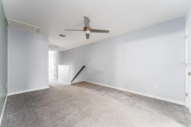 carpeted empty room with ceiling fan and a textured ceiling