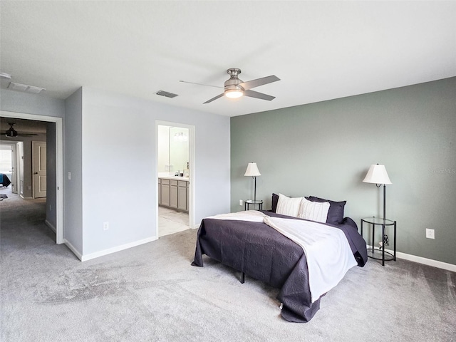 bedroom with connected bathroom, ceiling fan, and light carpet