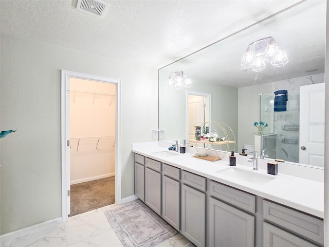 bathroom featuring vanity, an enclosed shower, and a textured ceiling