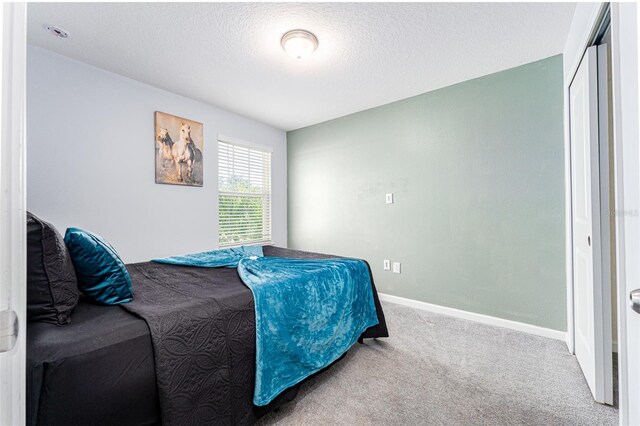 carpeted bedroom featuring a textured ceiling