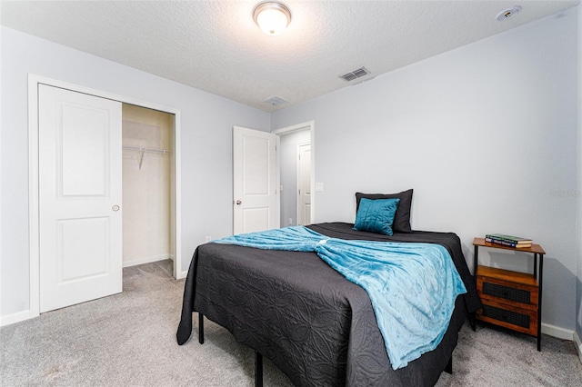 carpeted bedroom featuring a textured ceiling and a closet