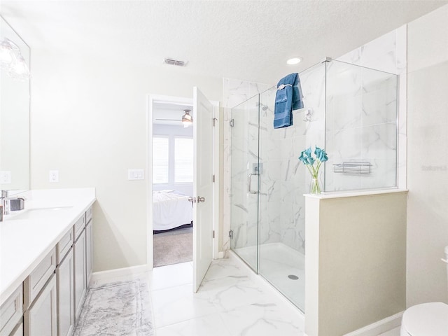 bathroom with a textured ceiling, vanity, toilet, and a shower with shower door