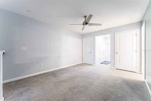 carpeted empty room featuring a textured ceiling and ceiling fan