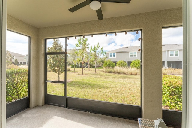 unfurnished sunroom with a wealth of natural light and ceiling fan