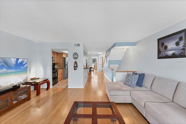 living room featuring a textured ceiling and light wood-type flooring