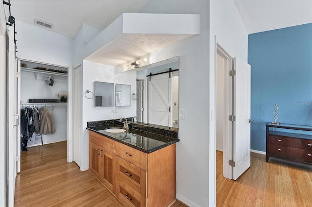 bathroom with vanity, a textured ceiling, and hardwood / wood-style flooring