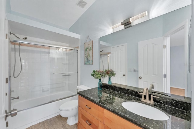 full bathroom featuring toilet, vanity, bath / shower combo with glass door, and wood-type flooring