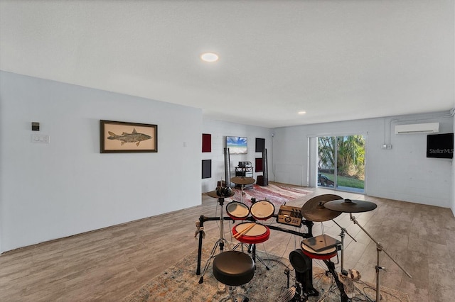 dining area featuring hardwood / wood-style flooring, a textured ceiling, and a wall unit AC