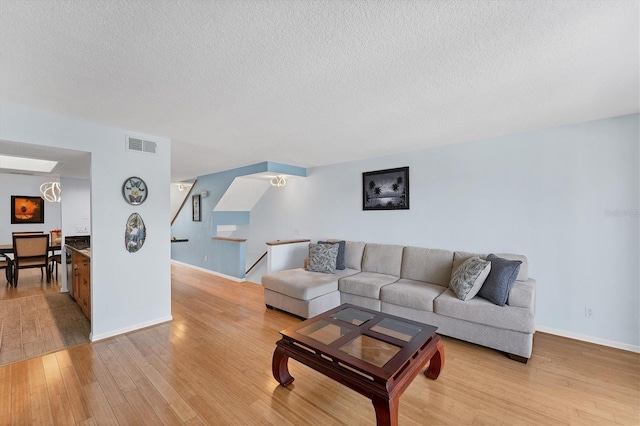 living room featuring a textured ceiling and light wood-type flooring