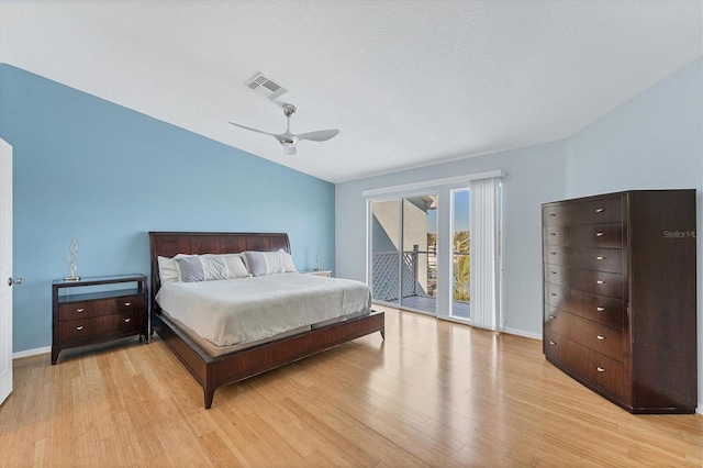 bedroom featuring access to outside, vaulted ceiling, ceiling fan, a textured ceiling, and light hardwood / wood-style floors