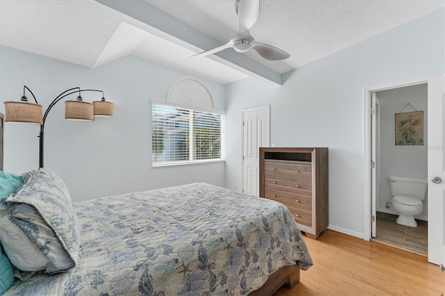 bedroom with ceiling fan, ensuite bathroom, a textured ceiling, and light wood-type flooring