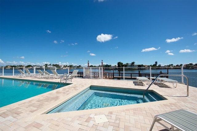 community pool with a water view and a patio area