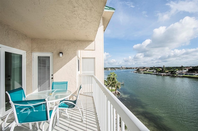 balcony featuring outdoor dining space and a water view