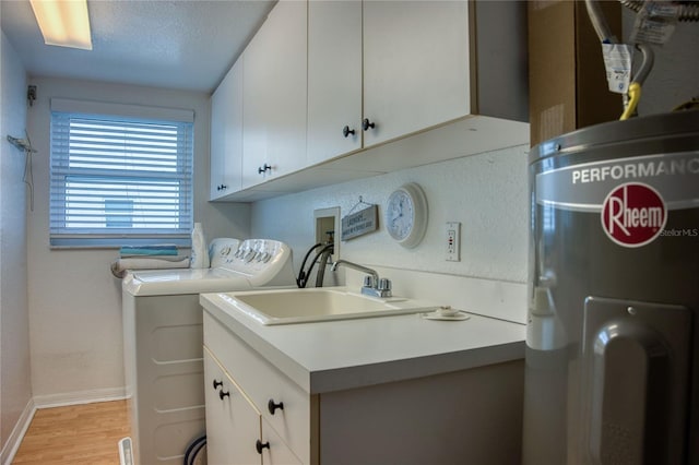 laundry area featuring baseboards, light wood-type flooring, water heater, separate washer and dryer, and a sink