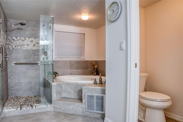 bathroom with a stall shower, visible vents, toilet, a textured ceiling, and a bath