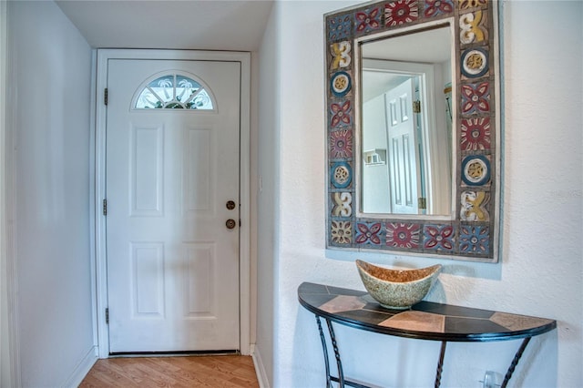 foyer with light wood-style floors and baseboards