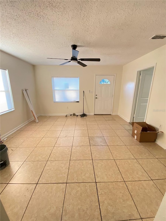 tiled entrance foyer with plenty of natural light, ceiling fan, and a textured ceiling