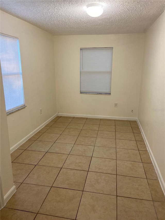 tiled spare room with a textured ceiling