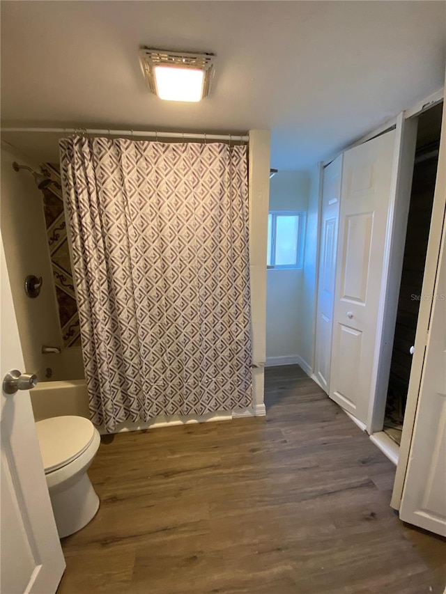 bathroom with wood-type flooring, toilet, and shower / bath combination with curtain