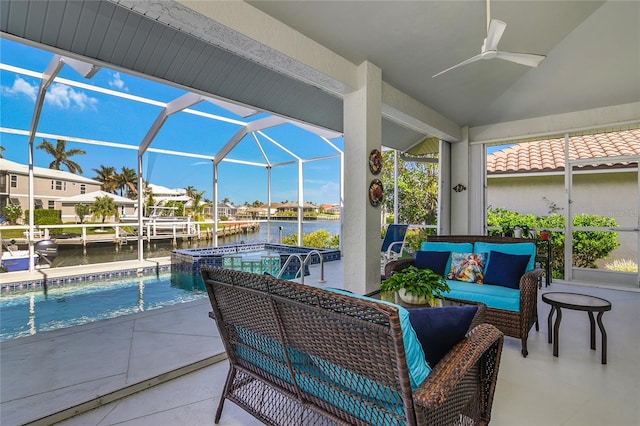 view of patio / terrace featuring an outdoor hangout area, a lanai, ceiling fan, a swimming pool with hot tub, and a water view