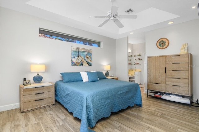 bedroom with wood-type flooring, ensuite bath, and ceiling fan