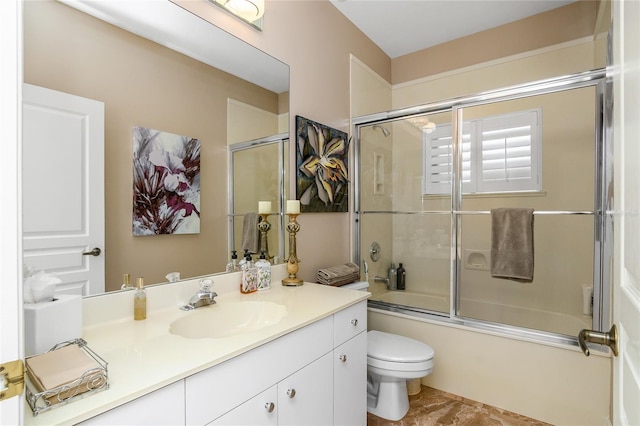 full bathroom featuring vanity, bath / shower combo with glass door, and toilet