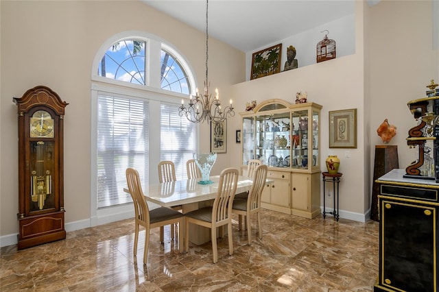 dining room with a high ceiling and a chandelier