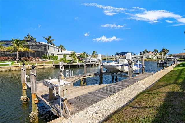 view of dock with a lawn and a water view