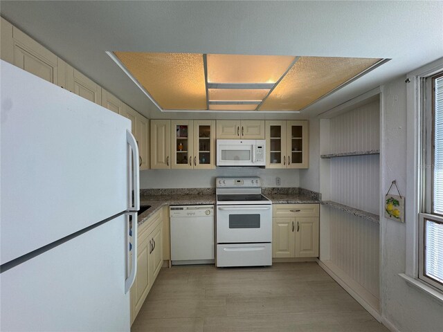 kitchen featuring light wood-type flooring, white appliances, a textured ceiling, and cream cabinets