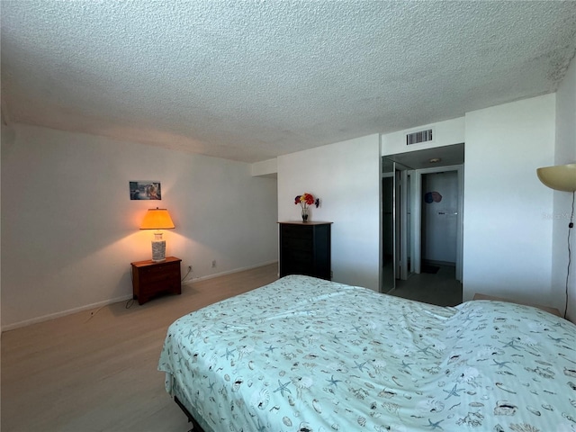 bedroom featuring hardwood / wood-style floors and a textured ceiling