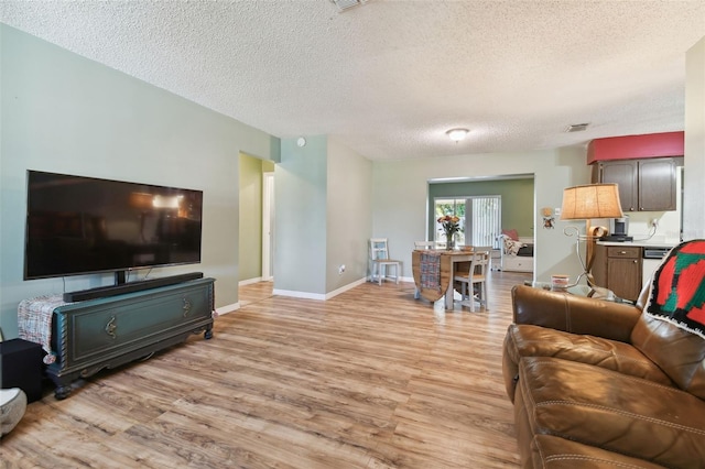 living room with light hardwood / wood-style flooring and a textured ceiling