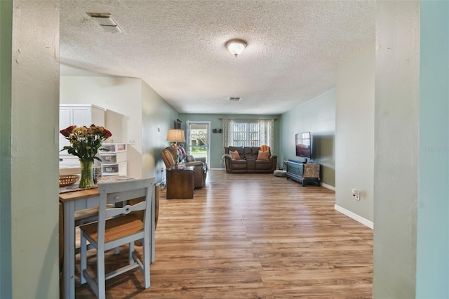 living room featuring light hardwood / wood-style floors and a textured ceiling