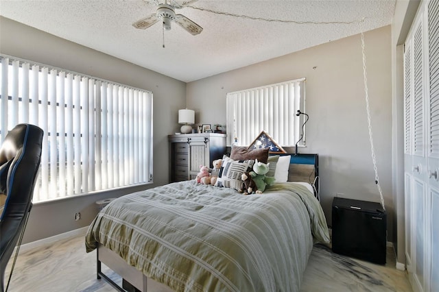 bedroom featuring ceiling fan, multiple windows, and a closet