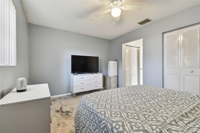 bedroom featuring ceiling fan, light carpet, and a textured ceiling