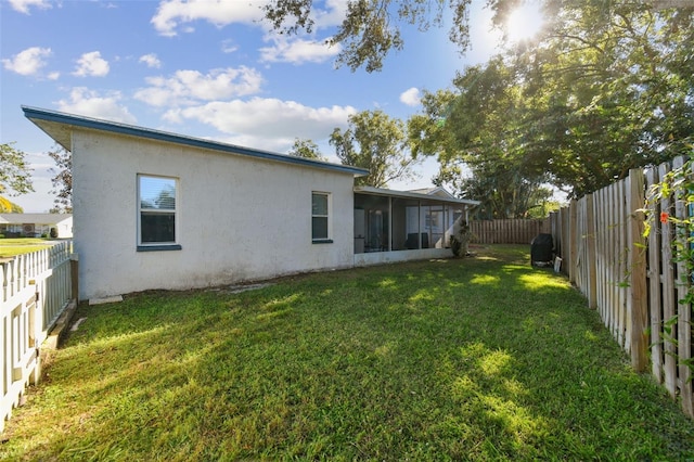 back of house featuring a yard and a sunroom