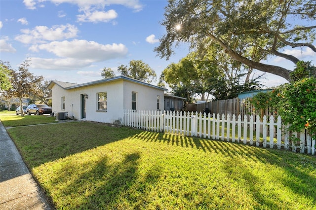 view of home's exterior with a lawn and central AC