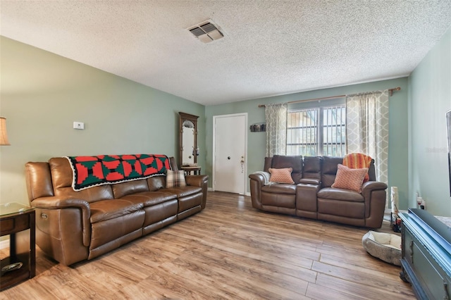 living room featuring a textured ceiling and light hardwood / wood-style flooring