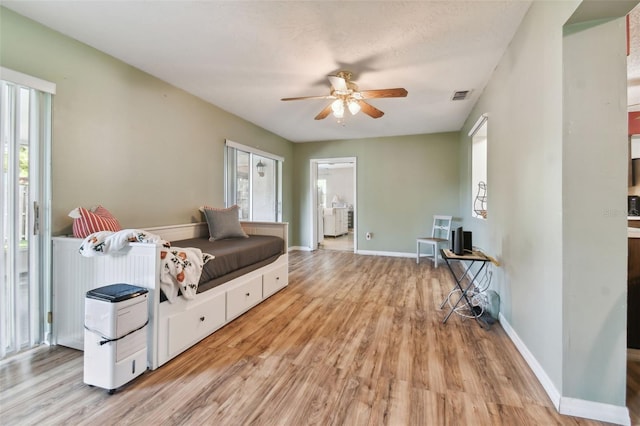 interior space with a wealth of natural light, ceiling fan, a textured ceiling, and light wood-type flooring