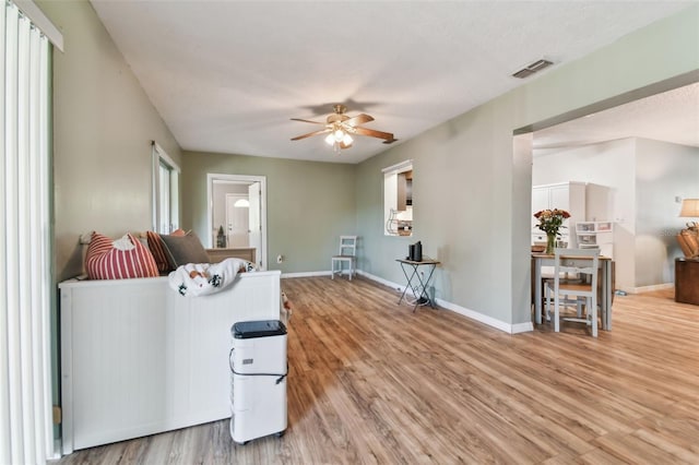 living room with ceiling fan and light hardwood / wood-style floors