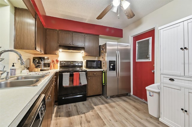 kitchen with sink, black appliances, a textured ceiling, and light hardwood / wood-style flooring