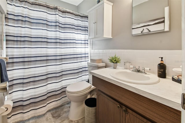 bathroom featuring a shower with curtain, vanity, toilet, and tile walls