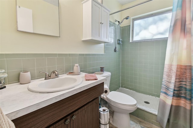 bathroom with vanity, toilet, curtained shower, and tile walls