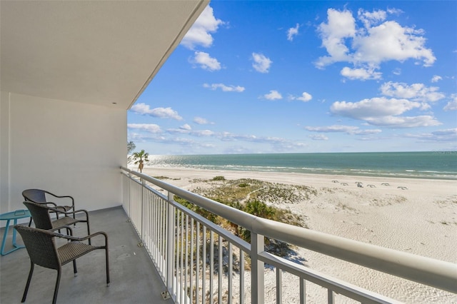 balcony featuring a water view and a beach view