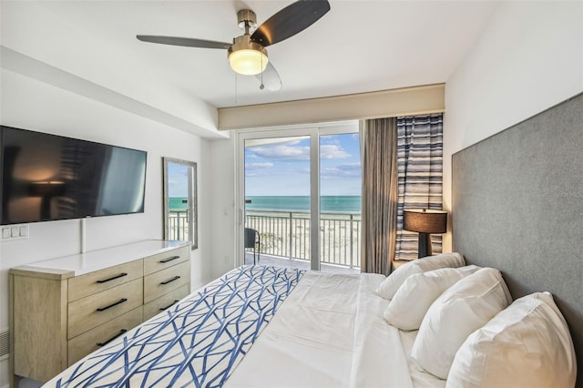 bedroom with access to outside, ceiling fan, a water view, and a view of the beach