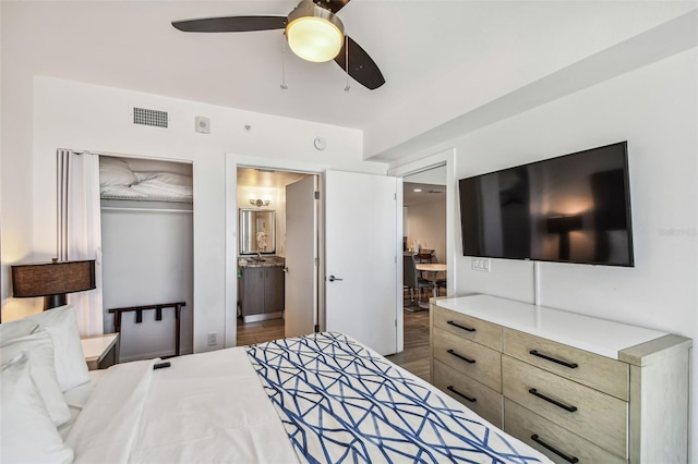 bedroom featuring dark hardwood / wood-style floors, ensuite bath, a closet, and ceiling fan