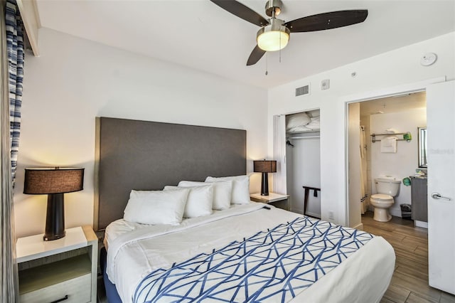 bedroom featuring connected bathroom, hardwood / wood-style flooring, a closet, and ceiling fan