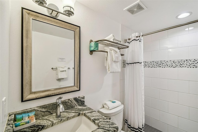 bathroom featuring vanity, toilet, and walk in shower