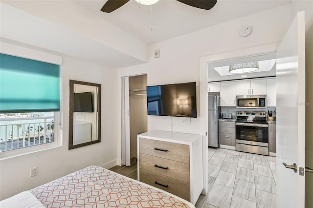 bedroom featuring ceiling fan, stainless steel fridge, and a closet